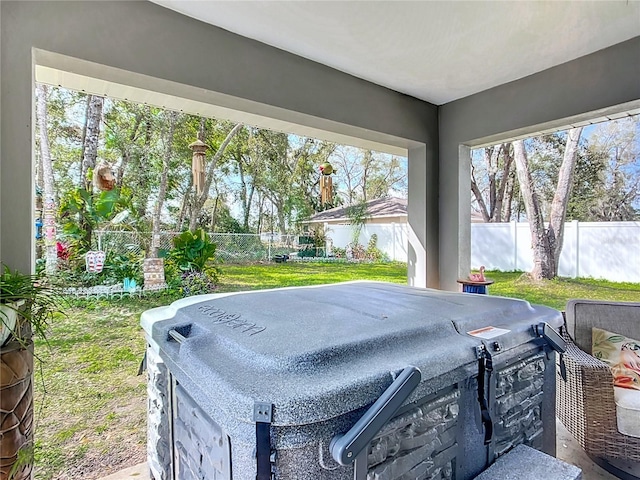 exterior space featuring a fenced backyard, a grill, and a hot tub