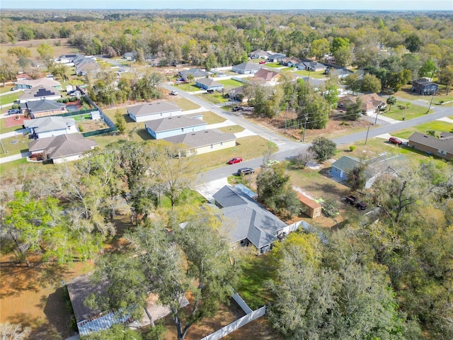 drone / aerial view featuring a residential view and a wooded view