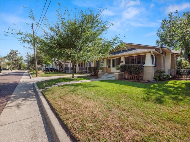 bungalow-style house featuring brick siding and a front lawn