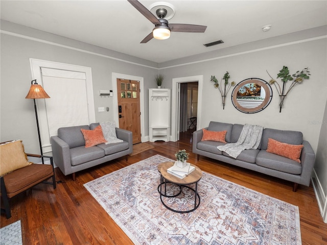 living room with visible vents, ceiling fan, baseboards, and wood finished floors