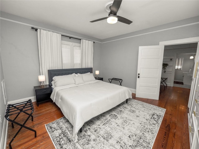 bedroom featuring dark wood-type flooring, baseboards, and a ceiling fan