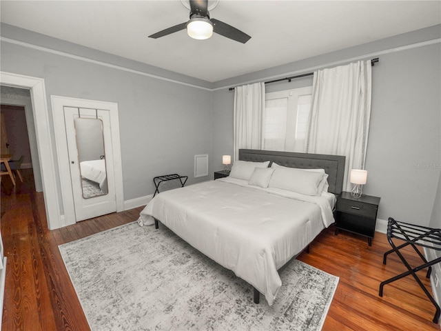 bedroom featuring ceiling fan, baseboards, and wood finished floors