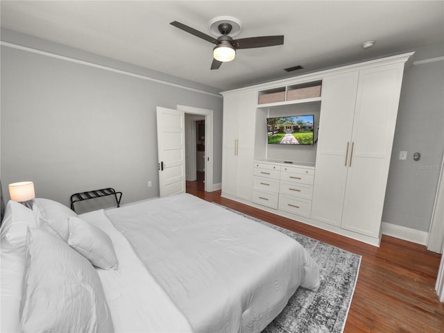 bedroom featuring dark wood-style floors, baseboards, visible vents, and a ceiling fan