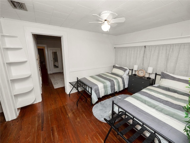 bedroom with wood finished floors, visible vents, and a ceiling fan