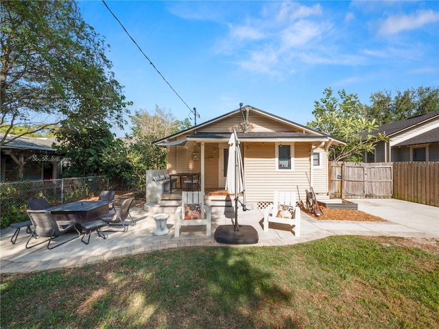 rear view of house featuring a yard, a patio, and fence