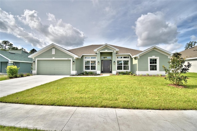 view of front facade with an attached garage, concrete driveway, a front yard, and stucco siding