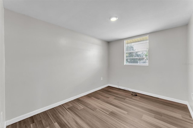 spare room featuring wood finished floors and baseboards