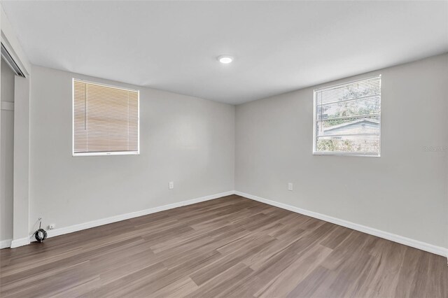 unfurnished bedroom featuring a closet, baseboards, and wood finished floors