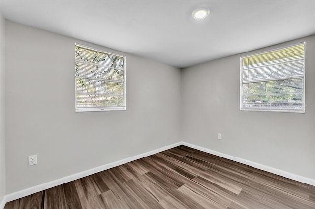 empty room with baseboards and wood finished floors