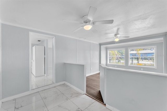 spare room featuring marble finish floor, baseboards, and ornamental molding