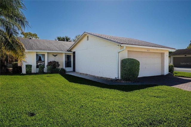 single story home with a garage, driveway, a front lawn, and stucco siding