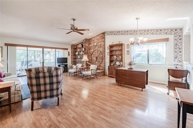 living room featuring vaulted ceiling, a textured ceiling, and a healthy amount of sunlight