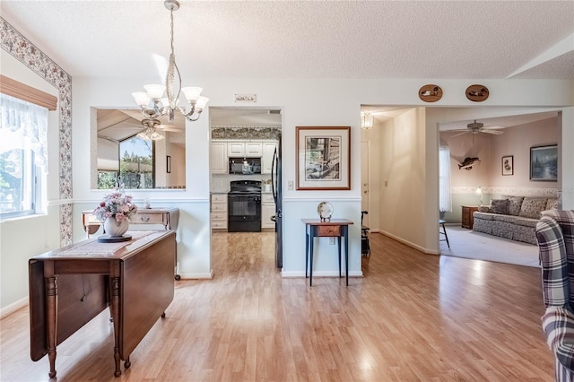 interior space with light wood finished floors, baseboards, and a textured ceiling