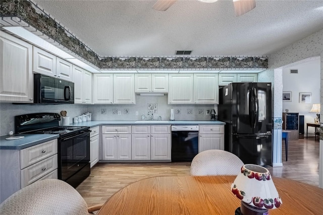 kitchen with black appliances, light wood-type flooring, a sink, and visible vents