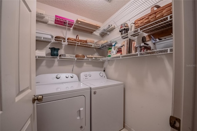 laundry area featuring laundry area, washer and clothes dryer, and a textured ceiling