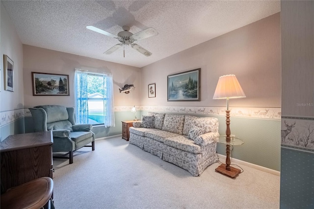 living room featuring carpet, baseboards, ceiling fan, and a textured ceiling