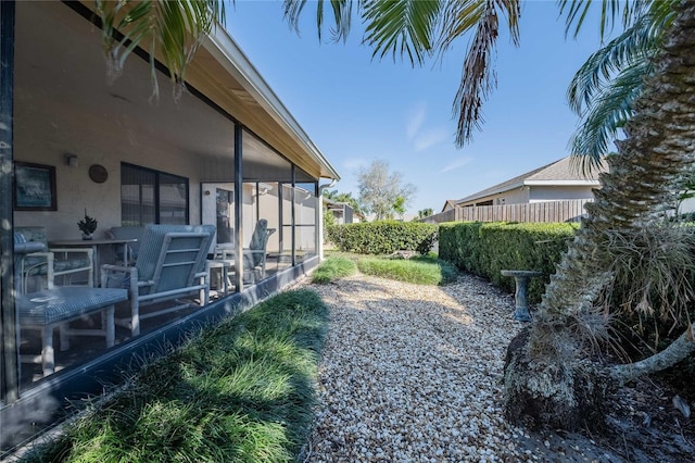 view of yard featuring a sunroom and fence