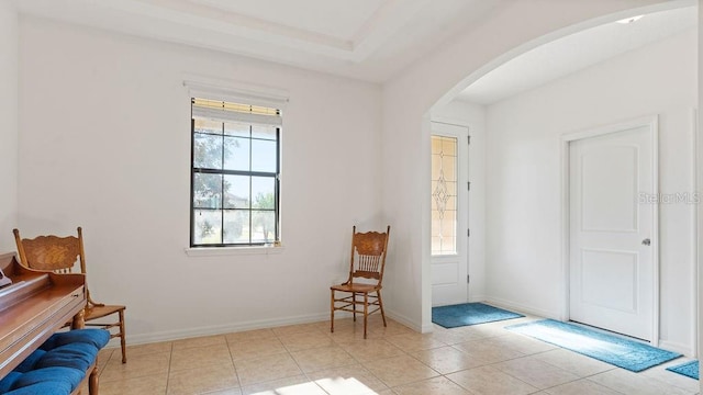 tiled entrance foyer featuring baseboards and arched walkways