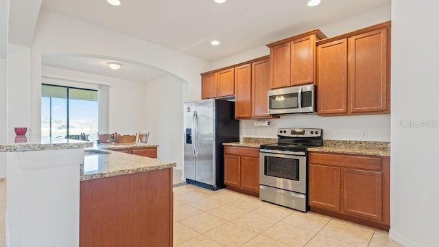 kitchen with appliances with stainless steel finishes, recessed lighting, and brown cabinets