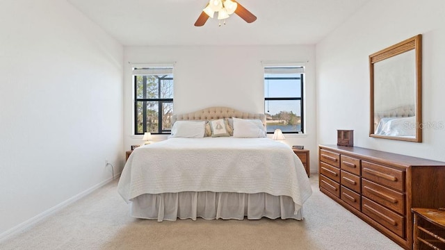 bedroom featuring a ceiling fan, light colored carpet, and baseboards