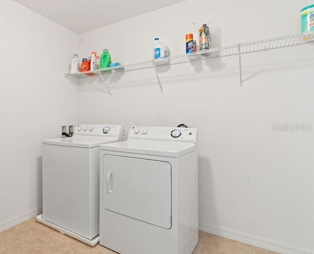 laundry room featuring laundry area, baseboards, and washing machine and clothes dryer