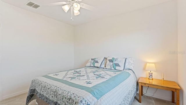 carpeted bedroom featuring a ceiling fan, visible vents, and baseboards