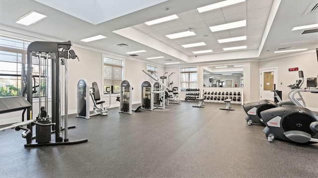 gym featuring a tray ceiling, baseboards, visible vents, and a drop ceiling