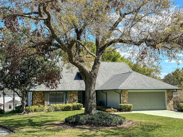 view of front of house with a garage, a front yard, stone siding, and a shingled roof