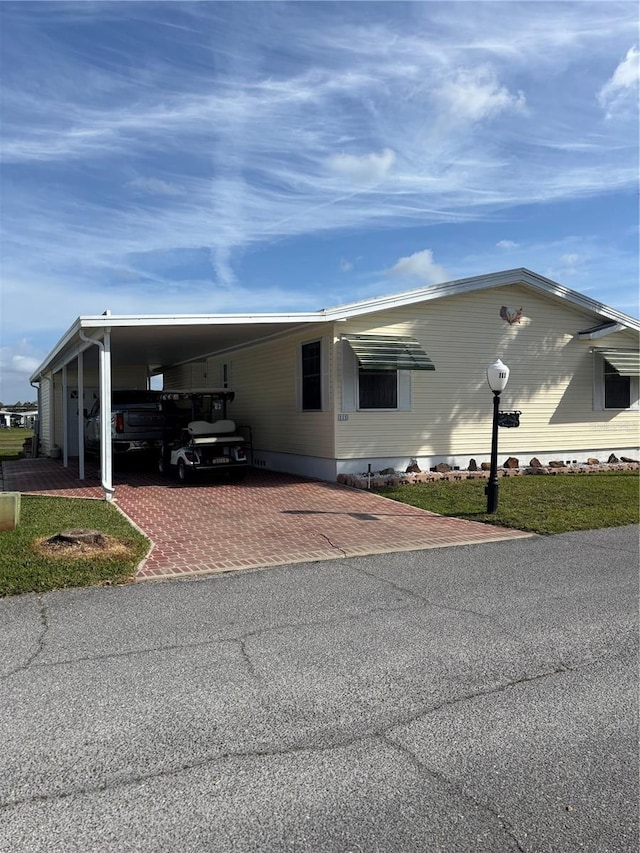 view of front facade with decorative driveway and a carport