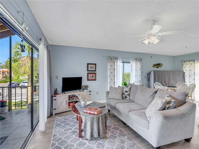 living area with a textured ceiling and a ceiling fan