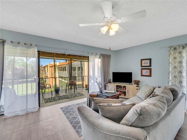 living room with a textured ceiling and ceiling fan