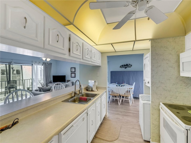 kitchen featuring white appliances, a ceiling fan, a sink, light countertops, and white cabinets