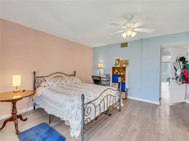 bedroom with ceiling fan, baseboards, and wood finished floors