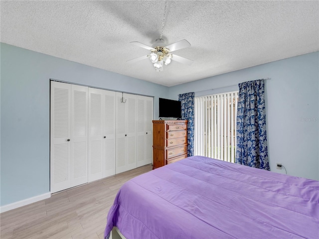 bedroom with a ceiling fan, a textured ceiling, wood finished floors, a closet, and baseboards