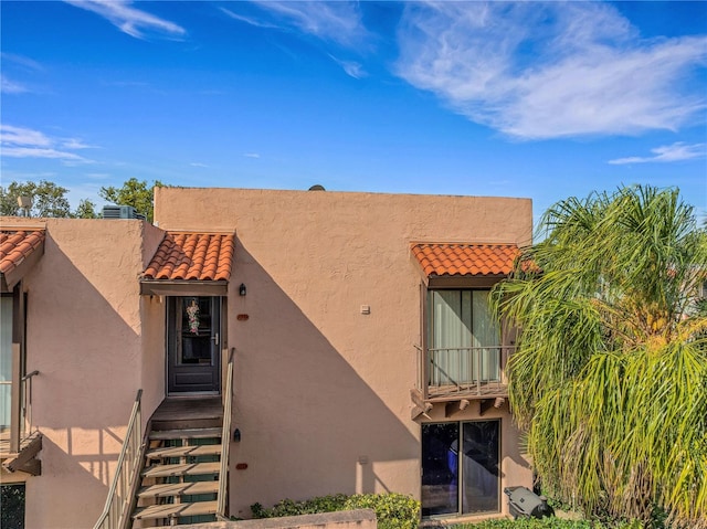 doorway to property featuring stucco siding and a tile roof