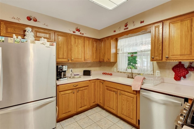 4643 1st St NW, Lakeland, FL 33810 - kitchen with stainless steel appliances, a sink, light tile patterned flooring, backsplash, and light countertops