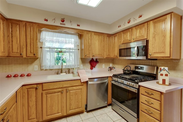 4643 1st St NW, Lakeland, FL 33810 - kitchen with a sink, light tile patterned flooring, backsplash, light countertops, and appliances with stainless steel finishes