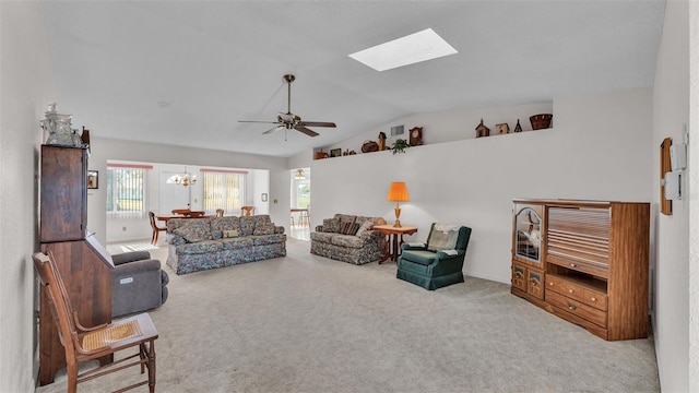 carpeted living room with lofted ceiling with skylight and ceiling fan with notable chandelier