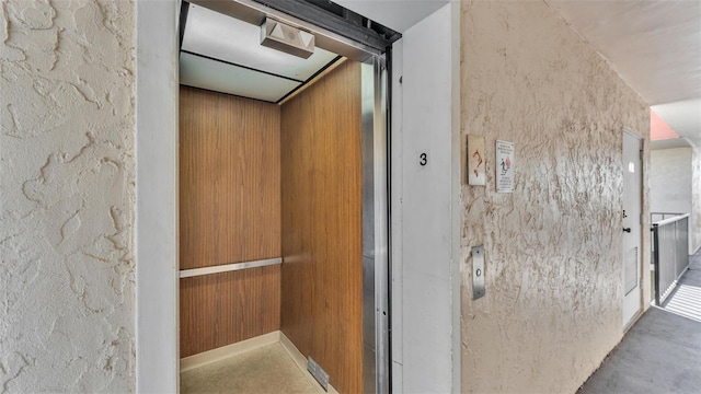 interior details featuring concrete flooring and elevator