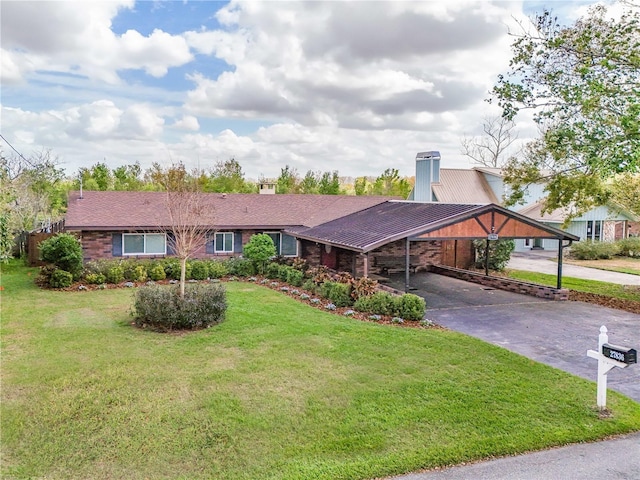 single story home with driveway, a front lawn, a carport, and brick siding