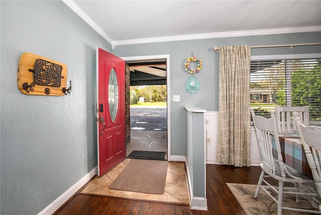 entryway featuring a textured wall, ornamental molding, wood finished floors, and baseboards