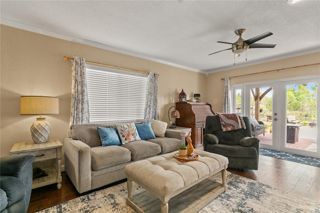 living room featuring a textured ceiling, ornamental molding, wood finished floors, and french doors