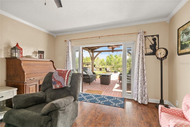 living room with ceiling fan, a textured ceiling, ornamental molding, and wood finished floors