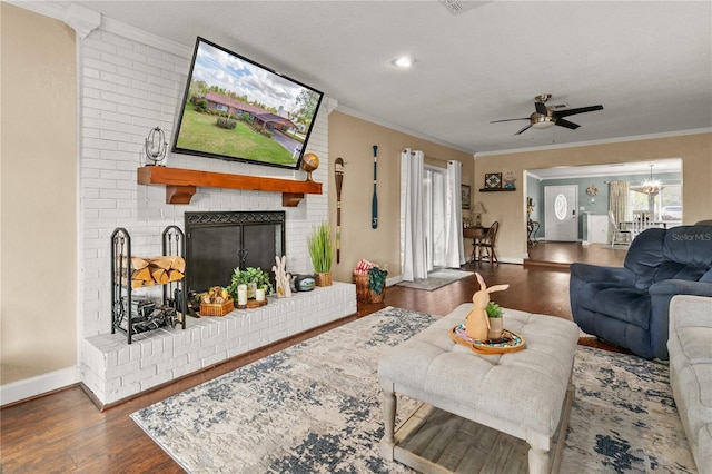 living room featuring crown molding, a fireplace, baseboards, and wood finished floors