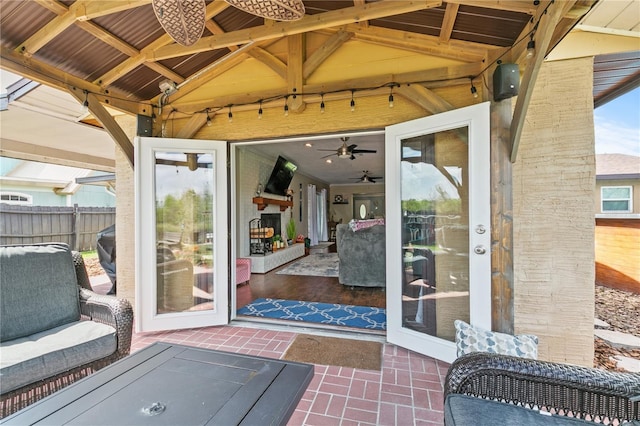 view of exterior entry featuring a patio area and fence