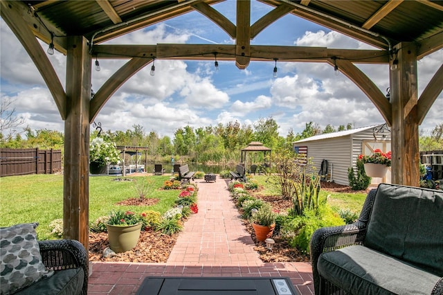 view of patio / terrace featuring a gazebo, an outdoor structure, and fence