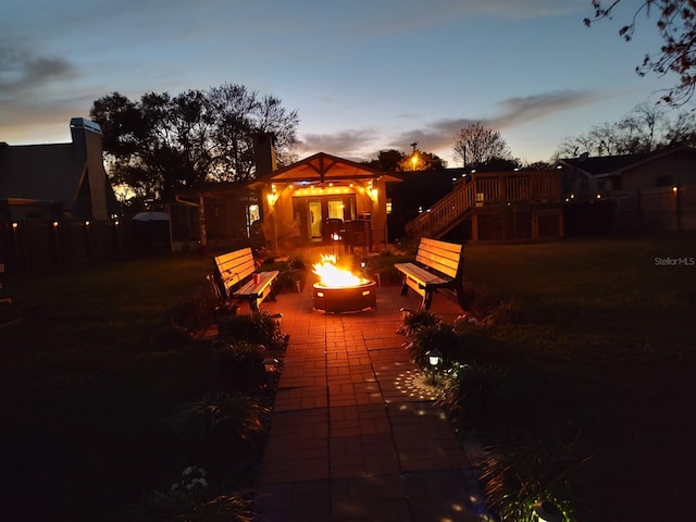 exterior space with fence, a fire pit, and a patio