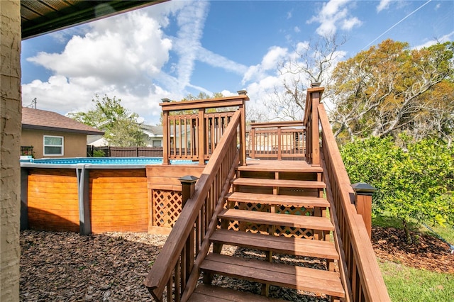 exterior space with stairway, fence, and a fenced in pool