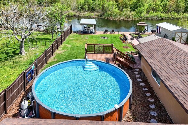 view of swimming pool with a gazebo, a lawn, a deck with water view, and fence