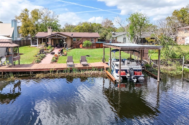 view of dock featuring a lawn, boat lift, a water view, fence, and a gazebo